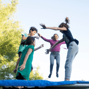 a group of 4 people jumping on a trampoline